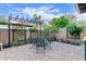 Charming outdoor dining area with a wrought iron table set amidst lush greenery and a pergola at 5443 W Hobby Horse Dr, Phoenix, AZ 85083