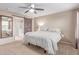 Main bedroom featuring a barn door to ensuite bathroom, ceiling fan, and natural light at 5443 W Hobby Horse Dr, Phoenix, AZ 85083