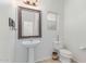 Powder room featuring pedestal sink, decorative mirror, and tile flooring at 5443 W Hobby Horse Dr, Phoenix, AZ 85083