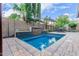 Sparkling swimming pool with a decorative water feature, surrounded by lush landscaping and a tiled patio at 5443 W Hobby Horse Dr, Phoenix, AZ 85083