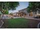 A sprawling backyard with a well-maintained lawn, shimmering pool, and covered patio offers a private retreat at 6172 W Kerry Ln, Glendale, AZ 85308