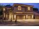 Striking nighttime view of a home boasting a three-car garage and desert-themed front yard at 6172 W Kerry Ln, Glendale, AZ 85308