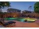 Pool area with rock features and string lights against the backdrop of adjacent houses and a twilight sky at 6172 W Kerry Ln, Glendale, AZ 85308