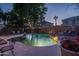Backyard pool area with waterfall feature, lounge chairs, potted plants, and string lights for evening enjoyment at 6172 W Kerry Ln, Glendale, AZ 85308