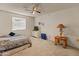Spacious bedroom features a ceiling fan, window, and neutral carpet at 6936 W Monterey Way, Phoenix, AZ 85033