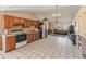 Bright, open-concept kitchen with tile floors, vaulted ceilings, wood cabinets, and a view into the living space at 6936 W Monterey Way, Phoenix, AZ 85033