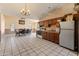 Open floor plan with a kitchen featuring oak cabinets, stainless-steel refrigerator, and tile flooring at 6936 W Monterey Way, Phoenix, AZ 85033