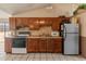 Traditional kitchen with wooden cabinets, stainless-steel refrigerator, and access to outdoor living area at 6936 W Monterey Way, Phoenix, AZ 85033