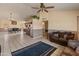 Inviting living room with tile flooring, vaulted ceilings, ceiling fan, and open kitchen and dining area at 6936 W Monterey Way, Phoenix, AZ 85033
