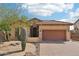 Lovely tan home features a two car garage, decorative stone, and low maintenance desert landscaping at 6937 E Sierra Morena Cir, Mesa, AZ 85207