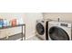 Modern laundry room featuring stainless steel washer and dryer, with storage shelves at 6937 E Sierra Morena Cir, Mesa, AZ 85207