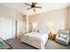 Comfortable bedroom with neutral colors, an accent chair and a view of the closet and the ensuite bathroom at 6937 E Sierra Morena Cir, Mesa, AZ 85207
