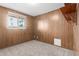 This bedroom features wood paneling, carpet, and a window letting in natural light at 7126 N 29Th Dr, Phoenix, AZ 85051