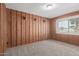 Bedroom with knotty pine paneling, carpet, and a window with blinds at 7126 N 29Th Dr, Phoenix, AZ 85051