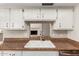 Close up of kitchen sink, cabinets, and granite counters looking towards a fireplace at 7126 N 29Th Dr, Phoenix, AZ 85051