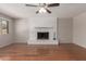 Inviting living room featuring hardwood floors and a painted brick fireplace, bathed in natural light at 7126 N 29Th Dr, Phoenix, AZ 85051
