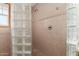 Close up of shower featuring glass block wall, ceramic tile, and shower head at 7126 N 29Th Dr, Phoenix, AZ 85051