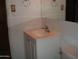 Bathroom features a vanity with white cabinets, a sink, a large mirror, and a toilet at 7821 W Clarendon Ave, Phoenix, AZ 85033