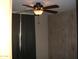 Bedroom features ceiling fan with light, neutral walls with wood trim and black curtains at 7821 W Clarendon Ave, Phoenix, AZ 85033