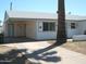 Wide concrete driveway leading to covered carport with palm tree in the front yard at 7821 W Clarendon Ave, Phoenix, AZ 85033