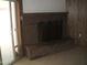 Living room showing a traditional brick fireplace with glass screen and tile flooring at 7821 W Clarendon Ave, Phoenix, AZ 85033