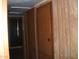 Hallway features storage closets and door to a bedroom and bathroom, with wooden accents and flooring at 7821 W Clarendon Ave, Phoenix, AZ 85033