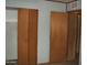 Bedroom hallway with bi-fold closet, neutral walls with flower pattern, doors, and tiled flooring at 7821 W Clarendon Ave, Phoenix, AZ 85033