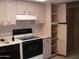 Well-lit kitchen showcasing white cabinets and modern black electric range at 7821 W Clarendon Ave, Phoenix, AZ 85033