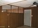 Living room featuring wood paneling, entry door, and ceiling fan to keep cool at 7821 W Clarendon Ave, Phoenix, AZ 85033