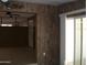 Living room with seamless flow and a view of the entryway, with tiled floors and wood paneling at 7821 W Clarendon Ave, Phoenix, AZ 85033