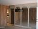 Open-concept living space features wood paneling and arched mirror accents at 7821 W Clarendon Ave, Phoenix, AZ 85033