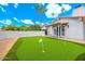 Backyard putting green with flags, adjacent to a white stucco home with a red tile roof and lush green surroundings at 7823 N Via Del Mundo --, Scottsdale, AZ 85258