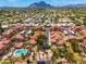 Stunning aerial view of a community with a pool and palm trees, set against a backdrop of mountains at 7911 E San Miguel Ave # 3, Scottsdale, AZ 85250