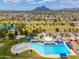 Breathtaking aerial view of the community pool with green spaces, ponds, and stunning mountain views in the background at 7911 E San Miguel Ave # 3, Scottsdale, AZ 85250