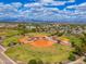 Aerial view of a baseball field and recreational facilities with mountain views in the background at 7911 E San Miguel Ave # 3, Scottsdale, AZ 85250