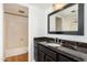 Bathroom features a dark granite countertop, wood cabinets, large mirror and tiled tub at 7911 E San Miguel Ave # 3, Scottsdale, AZ 85250