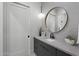 Modern bathroom featuring a round mirror, geometric tile accent wall, and elegant lighting fixture at 8520 E Cactus Wren Rd, Scottsdale, AZ 85250