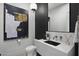 Stylish powder room showcasing a modern black sink, unique artwork, and elegant fixtures at 8520 E Cactus Wren Rd, Scottsdale, AZ 85250