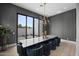Contemporary dining room with modern lighting fixture, dark accent wall, and sliding glass doors to the exterior at 8520 E Cactus Wren Rd, Scottsdale, AZ 85250
