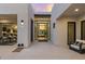 Modern entryway with glass front door, courtyard view, tile floors, and contemporary lighting at 8520 E Cactus Wren Rd, Scottsdale, AZ 85250