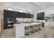 Modern kitchen featuring sleek black cabinets, an island with bar seating, and stainless steel appliances at 8520 E Cactus Wren Rd, Scottsdale, AZ 85250