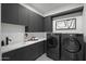 Well-equipped laundry room with modern washer and dryer, ample counter space, and stylish cabinetry at 8520 E Cactus Wren Rd, Scottsdale, AZ 85250