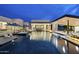 Expansive pool at dusk features a spa, in-water loungers, and inviting poolside bar area at 8520 E Cactus Wren Rd, Scottsdale, AZ 85250