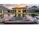 Luxurious pool and spa area with a built-in bar, outdoor kitchen, and inviting lounge space under striped umbrellas at 8520 E Cactus Wren Rd, Scottsdale, AZ 85250
