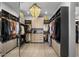 Spacious walk-in closet featuring custom shelving, drawers, and a stylish chandelier for ample storage at 8520 E Cactus Wren Rd, Scottsdale, AZ 85250