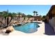 Resort style backyard featuring a pool with rock waterfall, lush landscaping, and a lounge chair at 10628 W Country Club Trl, Peoria, AZ 85383