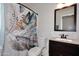Cozy bathroom featuring a single sink vanity, toilet and shower with feather curtain at 10628 W Country Club Trl, Peoria, AZ 85383