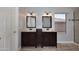 Bathroom featuring dual sinks, wood cabinets, tile floors, and a glass enclosed shower at 10628 W Country Club Trl, Peoria, AZ 85383