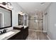 Elegant bathroom with double sinks, granite counters, wood cabinetry, and a tile and glass enclosed shower at 10628 W Country Club Trl, Peoria, AZ 85383