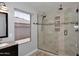 Modern bathroom featuring a glass-enclosed walk-in shower, window and a wood vanity at 10628 W Country Club Trl, Peoria, AZ 85383
